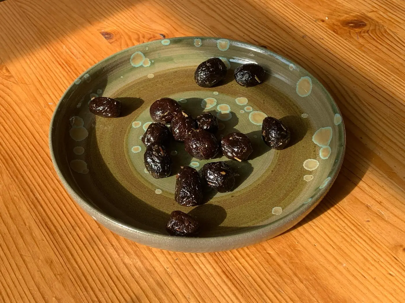 Assiette émaillée verte garnie d'olives noires