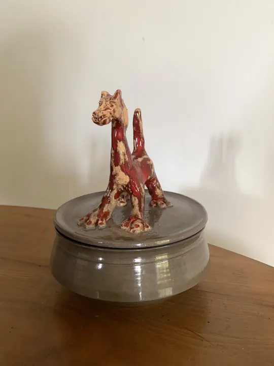 Boîte grise dont le couvercle porte un chat rouge et crème