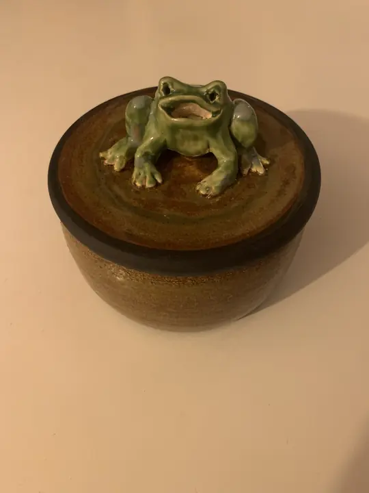 Boîte brune au couvercle surmonté d'une grenouille verte