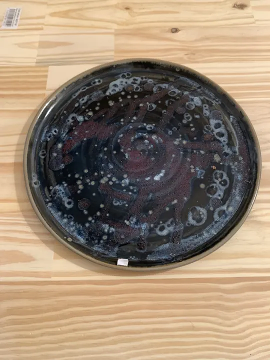 Grand plat noir moucheté de blanc et de rouge sombre