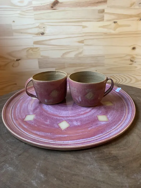 Deux tasses roses à losanges sur leur plateau assorti