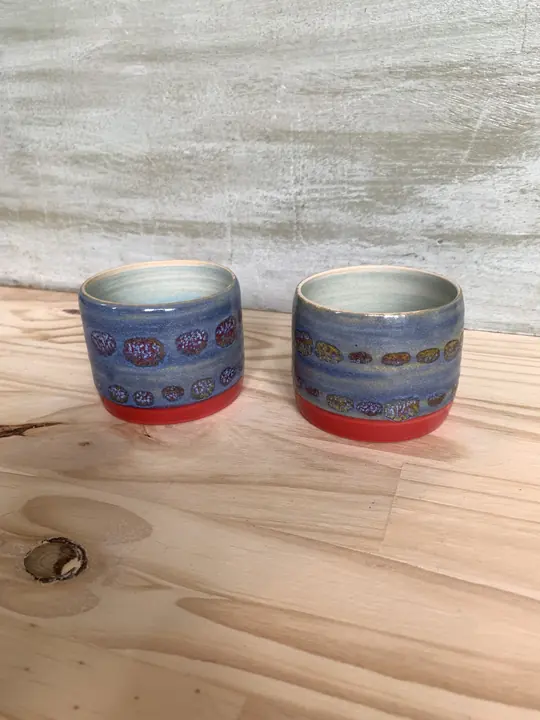 Deux gobelets bleus à pois, base rouge